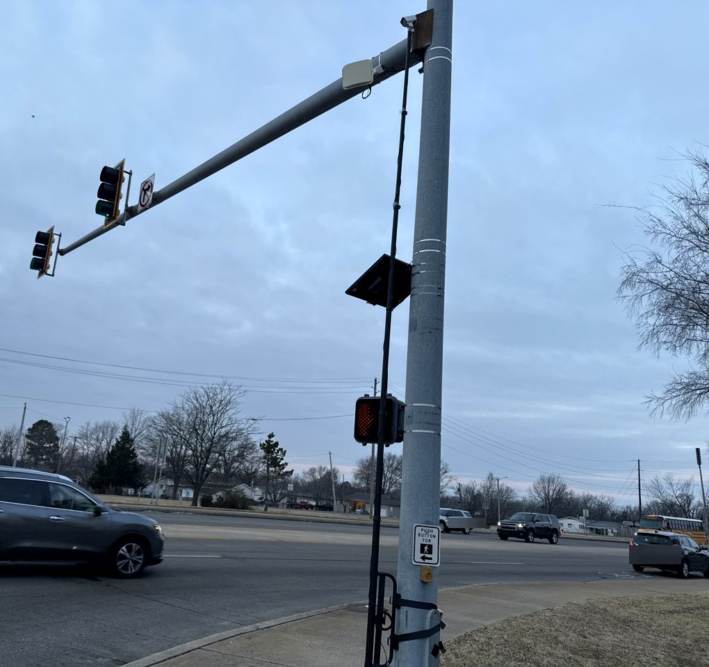 Compact video unit mounted on a pole beside a pedestrian signal at a signalized intersection
