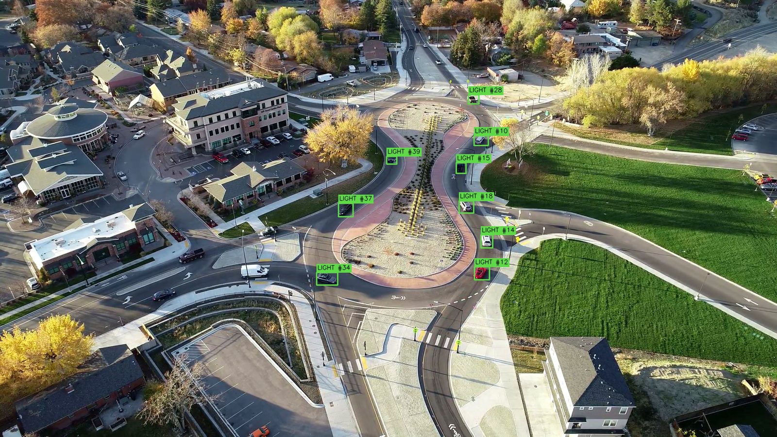 Aerial view of an elongated roundabout with each vehicle on the circulating roadway and its approaches marked by the tracking software